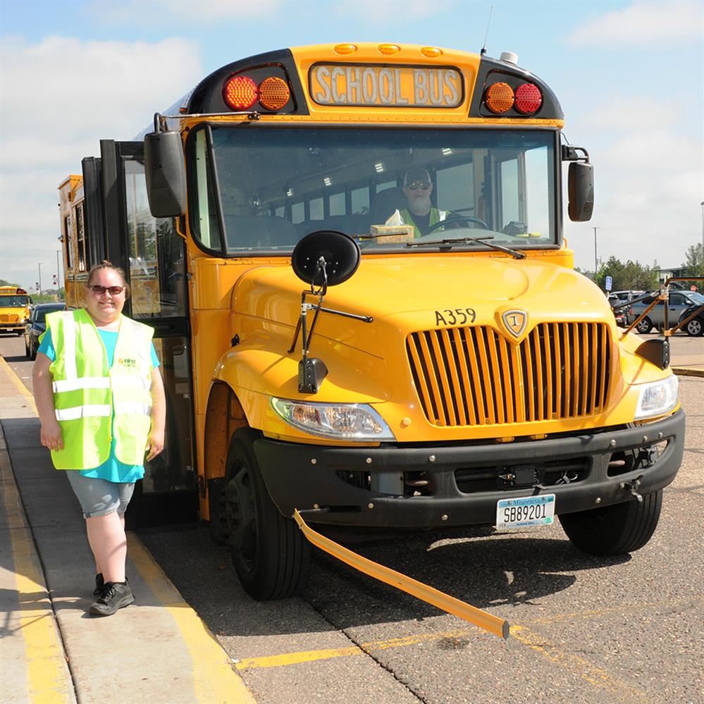 School bus para standing next to a bus with the stop arm extended